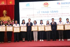 Thứ trưởng Bộ Giáo dục và Đào tạo Lê Quân và Bí thư Trung ương Đoàn Nguyễn Tường Lâm tặng bằng khen cho các giáo viên. (Ảnh: PV/Vietnam+)