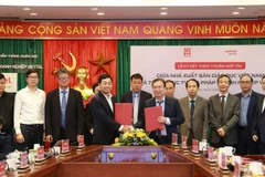 Ông Nguyễn Tiến Thanh - Chủ tịch Hội đồng thành viên, Tổng giám đốc Nhà xuất bản Giáo dục Việt Nam và ông Nguyễn Chí Thanh – Phó Tổng Giám đốc Tổng công ty Giải pháp Doanh nghiệp Viettel trao đổi văn bản thoả thuận hợp tác giữa hai đơn vị. (Ảnh: PV/Vietnam+)
