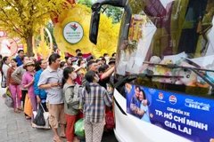 Người dân về quê đón Tết trên các chuyến xe miễn phí. (Ảnh: PV/Vietnam+)