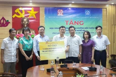 Ông Ngô Văn Hoan – Phó Tổng Giám đốc Nhà xuất bản Giáo dục Việt Nam trao biển tặng sách cho lãnh đạo Sở Giáo dục và Đào tạo tỉnh Nghệ An. (Ảnh: PV/Vietnam+)