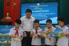 Nhà xuất bản Giáo dục Việt Nam tặng sách giáo khoa cho học sinh vùng lũ. (Ảnh: PV/Vietnam+)