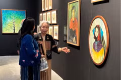 Nghệ sỹ Tô Bích Hải giới thiệu tranh với khách tham quan. (Ảnh: Minh Ngọc/Vietnam+).