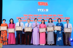 Đồng chí Vũ Việt Trang, Ủy viên Ban Thường vụ Đảng ủy các cơ quan Đảng Trung ương, Bí thư Đảng ủy, Tổng giám đốc Thông tấn xã Việt Nam, Phó trưởng ban Tuyên giáo và Dân vận Trung ương, Chủ tịch Liên chi hội Nhà báo Thông tấn xã Việt Nam tặng bằng khen cho các tập thể, cá nhân có đóng góp cho sự phát triển của Liên chi hội. (Ảnh: Hoài Nam/Vietnam+)