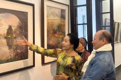Hoạ sỹ Trần Thanh Thục giới thiệu tranh tại triển lãm. (Ảnh: Minh Ngọc/Vietnam+).