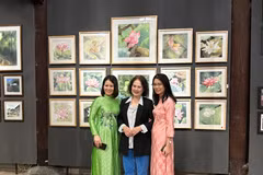 Khách tham quan chụp ảnh cùng các tác phẩm tại triển lãm. (Ảnh: Minh Ngọc/Vietnam+).