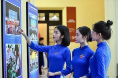 Cá đại biểu tham quan triển lãm ảnh về các hoạt động giao lưu, hợp tác giữa Trung ương Đoàn và thanh thiếu nhi hai nước Việt Nam - Trung Quốc. (Ảnh: PV/Vietnam+).