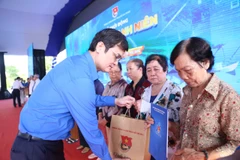 Bí thư Thứ nhất Trung ương Đoàn Bùi Quang Huy tặng quà cho người dân hoàn cảnh khó khăn, gia đình chính sách.(Ảnh: PV/Vietnam+).