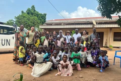 Ông Salim - Giám đốc Trung tâm (đứng ở giữa) cùng các em nhỏ chụp ảnh kỉ niệm cùng Tổ công tác. (Ảnh: PV/Vietnam+)