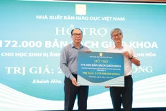 Ông Đặng Thanh Hải, Phó Tổng Giám đốc Nhà xuất bản Giáo dục Việt Nam trao tặng sách giáo khoa cho tỉnh Khánh Hòa. (Ảnh: Công Duy/Vietnam+)