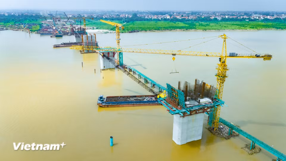 Ghi nhận thực tế tại khu vực thi công qua sông Hồng, diện mạo của cây cầu trọng điểm kết nối giữa huyện Mê Linh và huyện Đan Phượng (xã Ô Diên) đã dần hình thành. (Ảnh: Hoài Nam/Vietnam+)