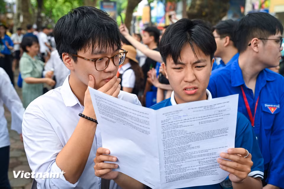 Cũng có thí sinh vẫn còn trăn trở với bài làm, trao đổi cùng bạn bè ngoài khu vực thi. (Ảnh: Minh Sơn/Vietnam+)
