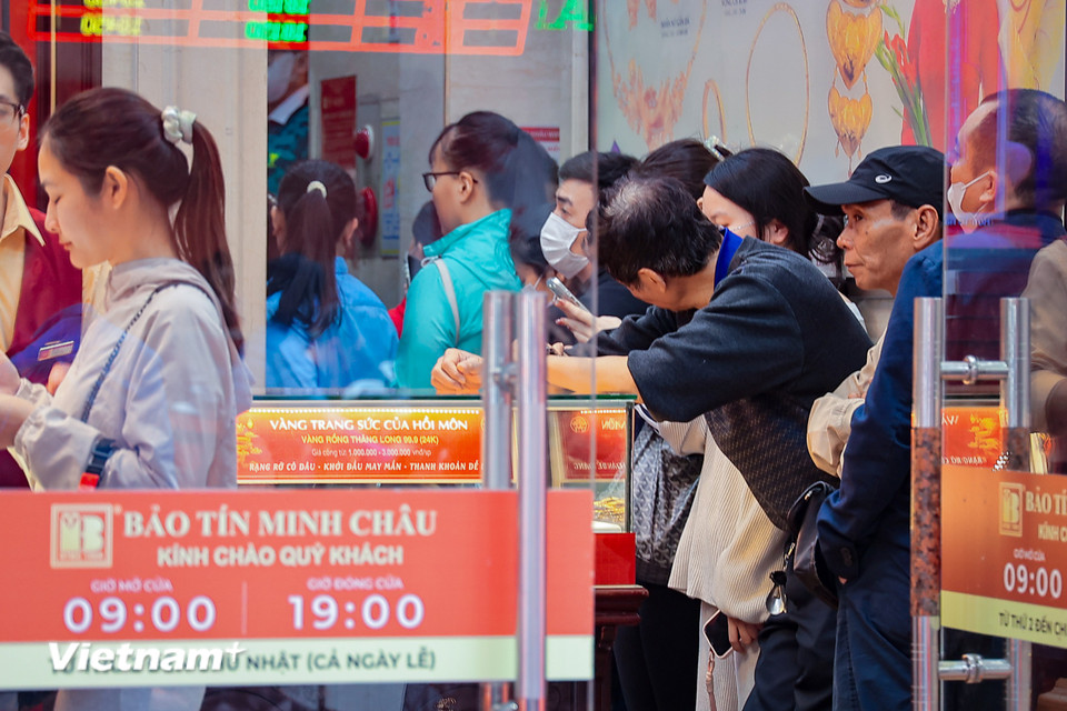 Nhiều người kiên nhẫn chờ đợi tới lượt giao dịch vàng trong đầu giờ chiều 23/2. (Ảnh: Hoài Nam/Vietnam+)