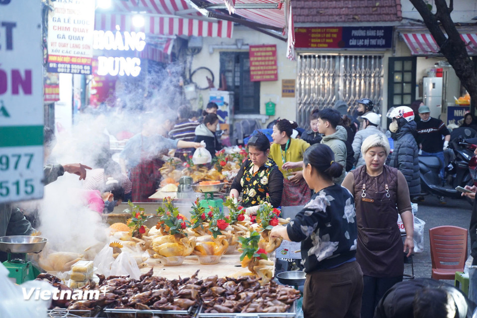Đông đảo người dân đã có mặt từ sớm để chuẩn bị những mâm cỗ cúng tươm tất, tiễn ông Công ông Táo về trời trước 12 giờ trưa. (Ảnh: Hoài Nam/Vietnam+)