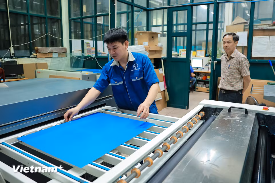Các kỹ thuật viên đã tập trung rà soát từng chi tiết trên bản kẽm trước khi đưa vào máy. (Ảnh: Hoài Nam/Vietnam+)