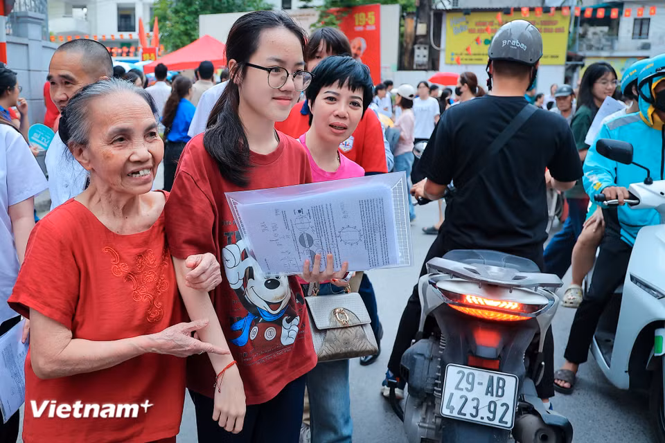 Bà Phẩm chia sẻ: “Cháu bảo vào phòng thi áp lực lắm nên bà phải đi cùng con," nên dù tuổi cao bà vẫn bám trụ ở khu vực cổng trường đợi cháu kết thúc môn thi. (Ảnh: Hoài Nam/Vietnam+)