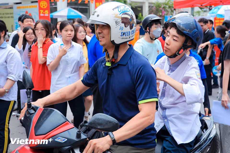 Anh Đinh Danh Lâm (46 tuổi, sống tại Định Công) ân cần chăm sóc con trai Đinh Thanh Sơn trong kỳ thi Trung học phổ thông với niềm tin và hy vọng dành cho con như cách anh đã làm 18 năm qua. (Ảnh: Hoài Nam/Vietnam+)