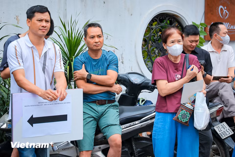 Nếu bên trong phòng thi là những cuộc đấu trí căng thẳng với đề bài, thì bên ngoài cổng trường, các phụ huynh cũng trải qua một "cuộc chiến" tâm lý không kém phần cam go. (Ảnh: Hoài Nam/Vietnam+)
