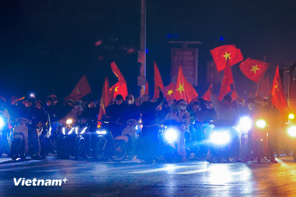 Người dân 'đi bão' không quên chấp hành nghiêm chỉnh tín hiệu đèn giao thông. (Ảnh: Hoài Nam/Vietnam+)