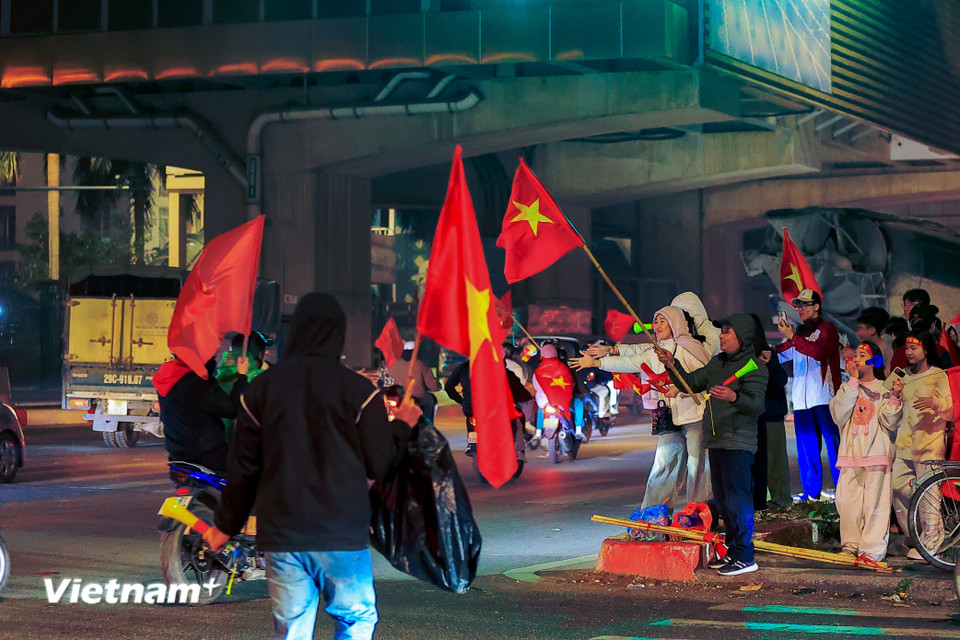 Mặc dù thời tiết mưa rét nhưng rất nhiều người vẫn đổ ra đường ăn mừng chiến thắng. (Ảnh: Hoài Nam/Vietnam+)
