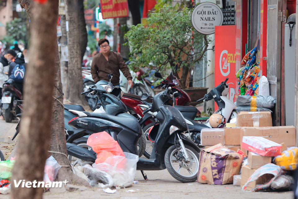 Nhiều khu vực vỉa hè vẫn bị lấn chiếm nghiêm trọng, không gian vỉa hè vẫn bị 'bóp nghẹt' bởi hàng hóa, phương tiện và rác thải. (Ảnh: Hoài Nam/Vietnam+)