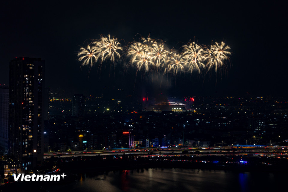 Ánh sáng của pháo hoa như tô thắm thêm sắc đỏ của lá cờ Đảng, củng cố niềm tin sắt son vào vận hội mới của đất nước. (Ảnh: Hoài Nam/Vietnam+)