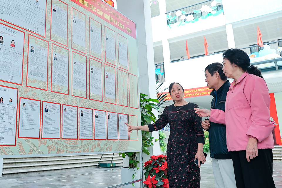 Trong những ngày Hà Nội rực rỡ cờ hoa chào đón ngày hội lớn của toàn dân, tại nhiều điểm bỏ phiếu, hình ảnh các bà, các chị miệt mài “đi từng ngõ, gõ từng nhà, rà từng người” để phát thẻ cử tri, thông tin về người ứng cử đã trở nên quen thuộc. (Ảnh: Hoài Nam/Vietnam+)