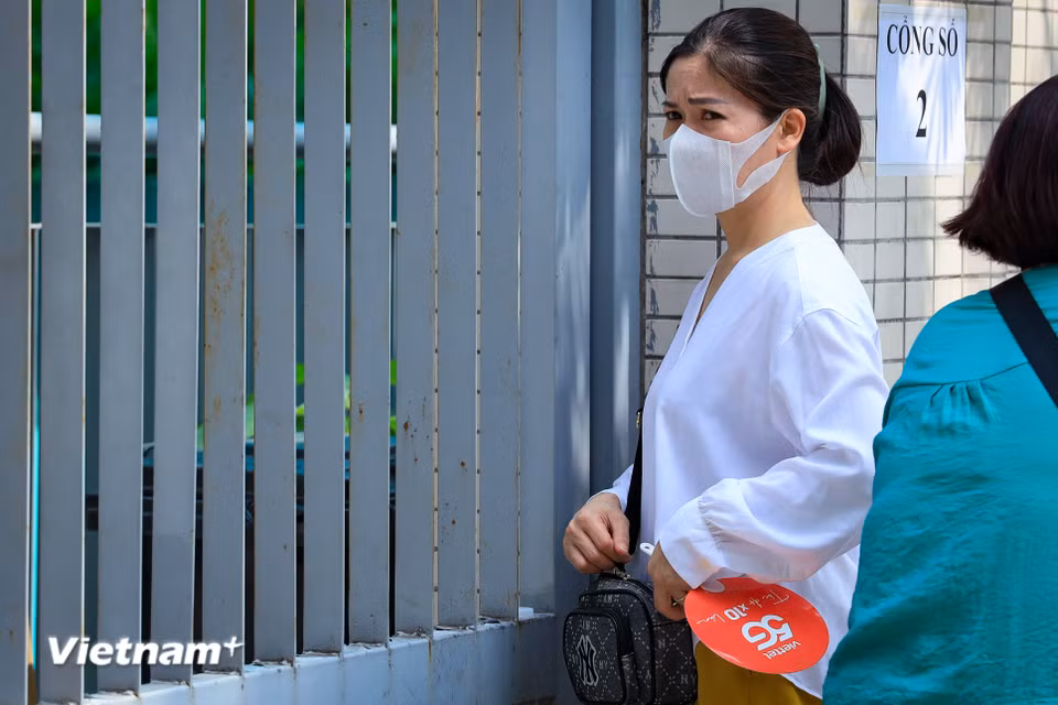 Suốt nhiều giờ đồng hồ con làm bài bên trong, là chừng ấy thời gian bố mẹ đứng ngồi không yên bên ngoài vỉa hè. (Ảnh: Hoài Nam/Vietnam+)