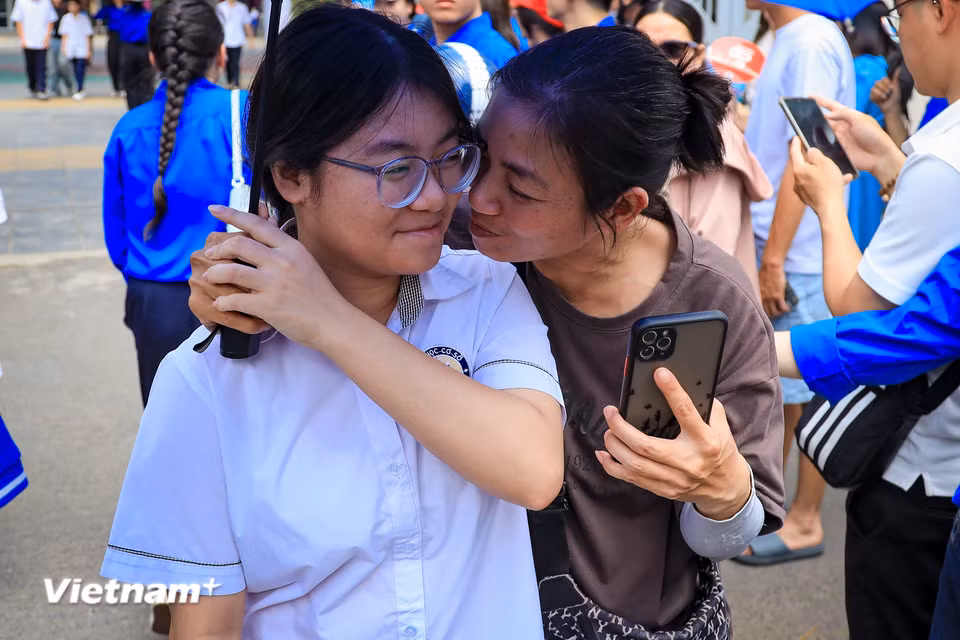 Hay những nụ hôn tình cảm, một cảm xúc vỡ òa của phụ huynh khi con thông báo làm bài tốt. (Ảnh: Hoài Nam/Vietnam+)