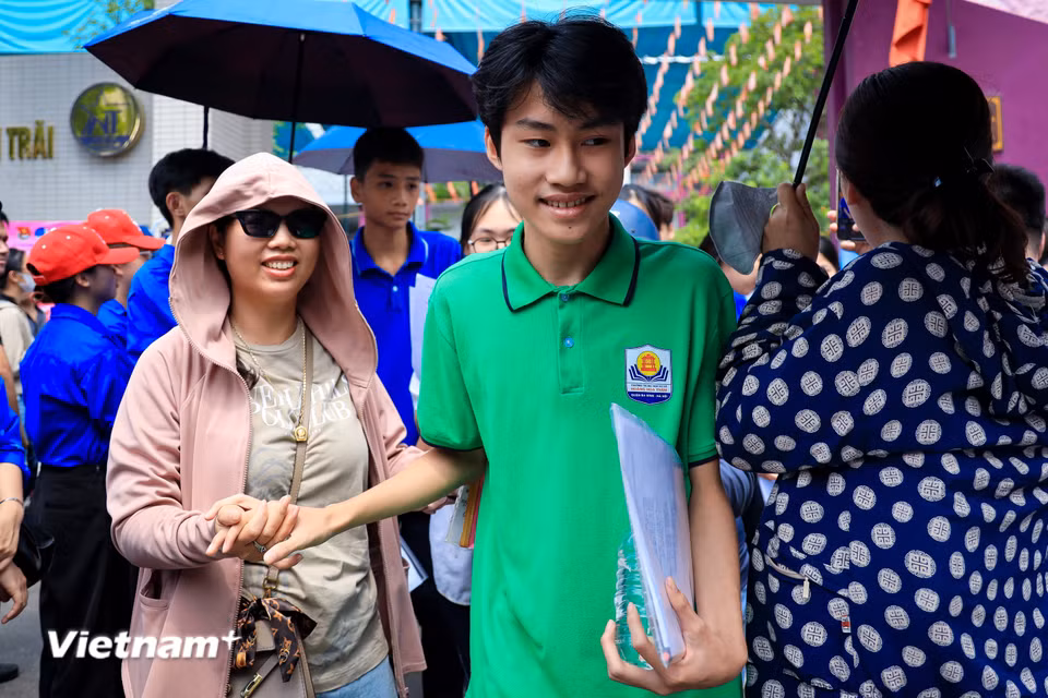 Những cái nắm tay thật chặt động viên con sau giờ thi. (Ảnh: Hoài Nam/Vietnam+)
