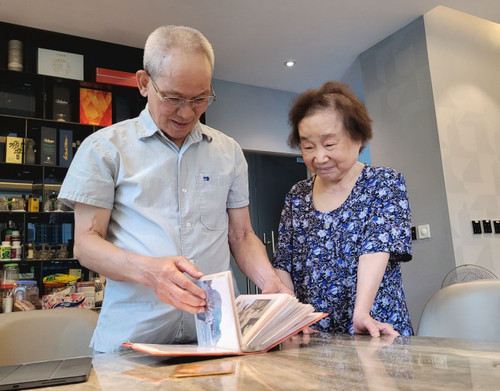 Ông Mai Liêm Trực và phu nhân xem lại những tấm ảnh cũ thời học sinh miền Nam. (Ảnh: Minh Anh/Vietnam+) mailiemtruc.jpg