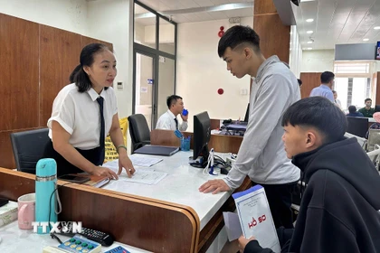 Cán bộ Trung tâm hành chính công phường Tam Kỳ, thành phố Đà Nẵng, hướng dẫn người dân làm thủ tục hành chính. (Ảnh: Trần Tĩnh/TTXVN)