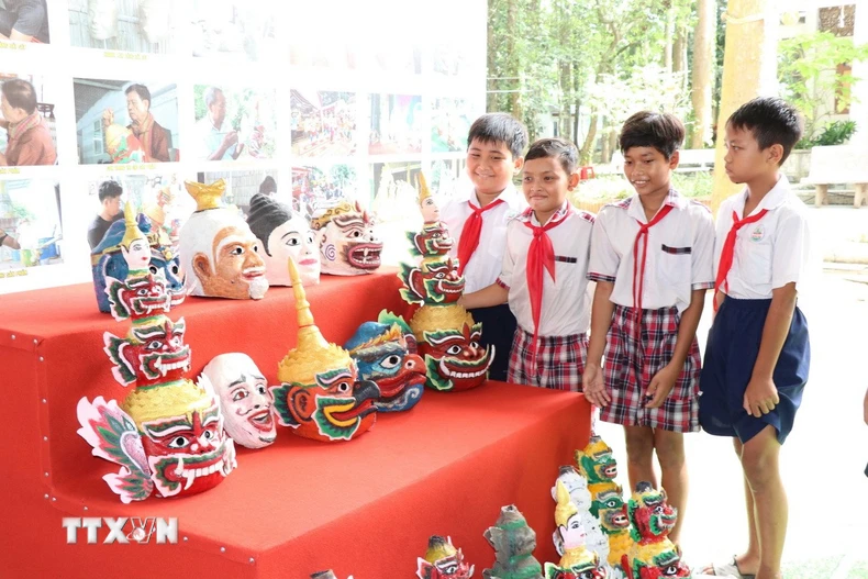 Các học sinh tham quan, tìm hiểu mão, mặt nạ của đồng bào Khmer. (Ảnh: Thanh Hòa/TTXVN)