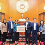 Bà Đoàn Thị Tuyết Nhung, Ủy viên Ban Thường vụ Đảng ủy, Phó Tổng giám đốc TTXVN trao ủng hộ cho đại diện Uỷ ban Trung ương Mặt trận Tổ quốc Việt Nam, ông Cao Xuân Thạo, Uỷ viên Đoàn chủ tịch, Trưởng Ban công tác Xã Hội. (Ảnh: Lê Đông/TTXVN)