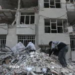 Người dân tìm kiếm đồ đạc trong đống đổ nát của những tòa nhà bị phá hủy sau các cuộc tấn công tại Tehran, Iran, ngày 12/3/2026. (Ảnh: THX/TTXVN)