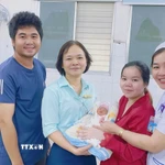 Bé sơ sinh được xuất viện trong niềm vui của gia đình và đội ngũ y bác sỹ. (Ảnh: TTXVN phát)