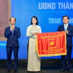 Phó chủ tịch Ủy ban Nhân dân Thành phố Hồ Chí Minh Trần Thị Diệu Thúy tặng cờ truyền thống cho Báo Thanh Niên. (Ảnh: Độc Lập)