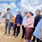 Ông Đinh Xuân Hoàng, đại diện tập đoàn Việt Phương-phụ trách triển khai Dự án Tổ hợp khai thác mỏ bauxite và chế biến alumin Dakcheung, báo cáo với Phó Chủ tịch Quốc hội Lào Sounthone Xayachak cùng Đoàn tại buổi làm việc ngoài công trường. (Ảnh: Xuân Tú/TTXVN)