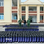 Đối tượng Phạm Đình Đạt và tang vật hơn 1.300 bình khí cười. (Ảnh: TTXVN phát)