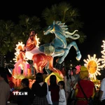 Du khách tham quan linh vật ngựa ở bờ Nam sông Hương, thành phố Huế dịp Tết Bính Ngọ 2026. (Ảnh: Nguyên Lý/TTXVN)