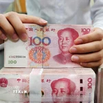 Kiểm tiền mệnh giá 100 nhân dân tệ tại một ngân hàng ở Nam Thông, tỉnh Giang Tô (Trung Quốc). (Ảnh: THX/TTXVN)