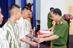 Đại tá Phạm Văn Duyên, Giám thị Trại giam Cao Lãnh trao quyết định giảm thời hạn chấp hành án phạt tù. (Ảnh: TTXVN phát)