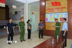 Lực lượng chức năng đọc lệnh khởi tố các đối tượng sản xuất giá đỗ bằng hóa chất độc. (Ảnh TTXVN phát)