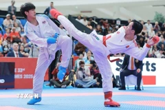 Khuất Hải Nam (đai đỏ) xuất sắc đánh bại võ sỹ nước chủ nhà để giành HCV nội dung Kumite hạng cân dưới 67kg. )(Ảnh: Minh Quyết/TTXVN)