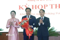 Ông Nghiêm Xuân Thành (phải), Bí thư Tỉnh ủy và bà Phạm Thị Xuân Trang, Phó Chủ tịch HĐND tỉnh Khánh Hòa tặng hoa chúc mừng ông Nguyễn Khắc Toàn được bầu giữ chức Chủ tịch UBND tỉnh Khánh Hòa nhiệm kỳ 2021-2026. (Ảnh: Phan Sáu/TTXVN)