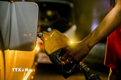 Bơm xăng cho phương tiện tại trạm xăng. (Ảnh: THX/TTXVN)