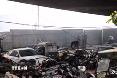 Lực lượng chức năng tiếp cận hiện trường vụ cháy bãi xe tại khu vực chân cầu Vĩnh Tuy (Hà Nội). (Ảnh: Vũ Quang/TTXVN)