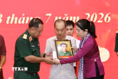 Phút nghẹn ngào của thân nhân liệt sỹ đón nhận di ảnh liệt sỹ đã được phục dựng. (Ảnh: Xuân Khu/TTXVN)