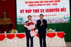 Ông Nguyễn Hoài Anh, Bí thư Tỉnh ủy, Chủ tịch HĐND tỉnh, tặng hoa chúc mừng ông Đỗ Hữu Huy được bầu giữ chức Chủ tịch UBND tỉnh Bình Thuận. (Ảnh: Nguyễn Thanh/TTXVN)