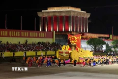 Xe mô hình Quốc huy nước Cộng hòa xã hội chủ nghĩa Việt Nam đi đầu khối diễu binh, diễu hành. (Ảnh: Quốc Khánh/TTXVN)