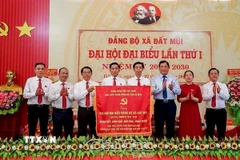 Thay mặt Tỉnh ủy, Phó Chủ tịch UBND tỉnh Cà Mau Lâm Văn Bi (thứ 3 từ phải sang), trao tặng Đại hội bức trướng mang dòng chữ "Đoàn kết-Dân chủ-Đột phá-Phát triển" khai thác lợi thế, phát triển Đất Mũi thành đô thị sinh thái hiện đại ở cực Nam của Tổ quốc. (Ảnh TTXVN phát)